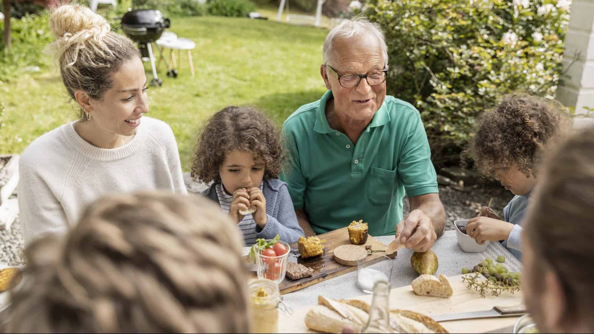 Famille à la table de midi dans le jardin