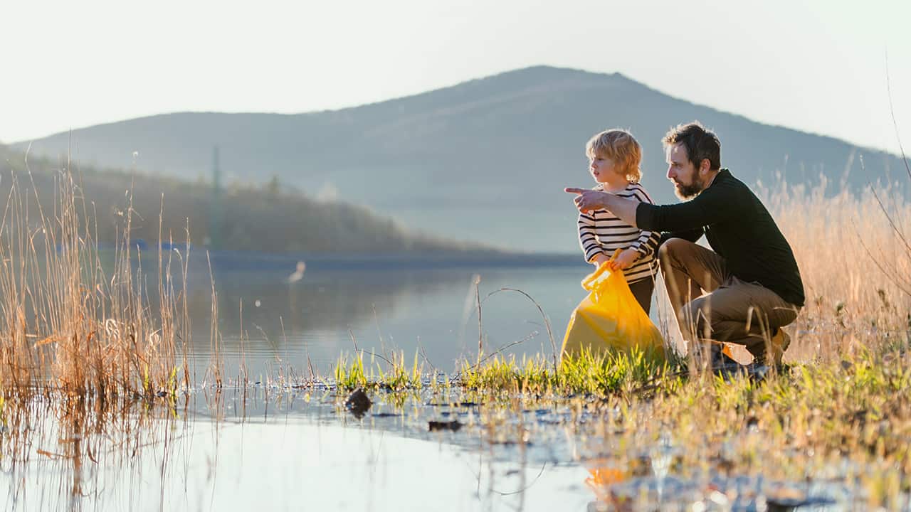 Vater und Sohn säubern einen See